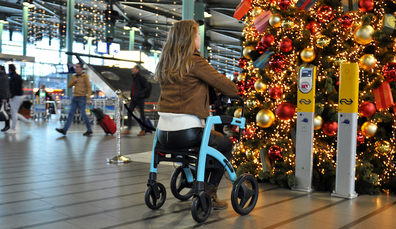 Young lady in airport sitting in a rollator