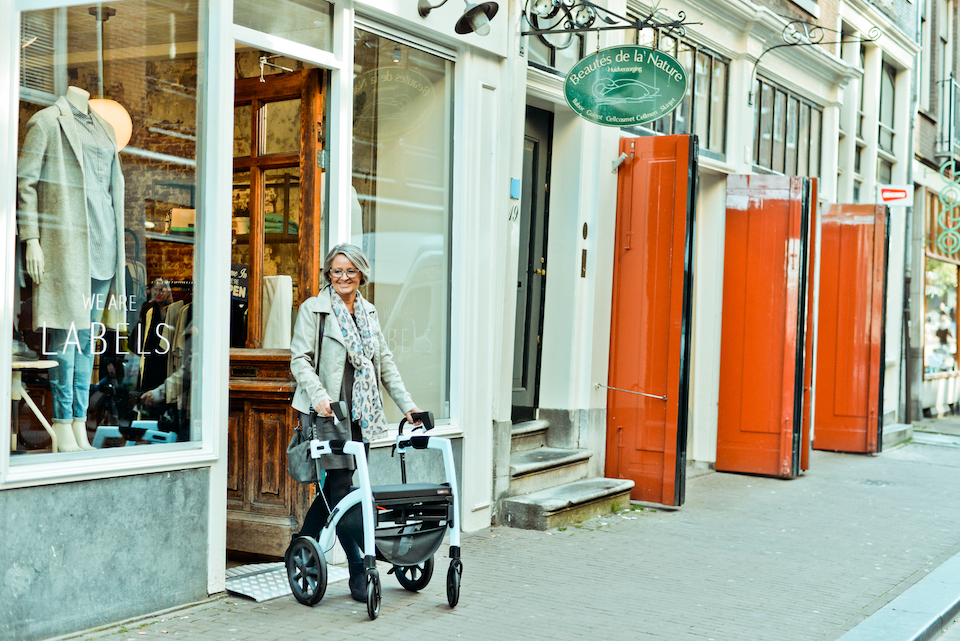 Lady getting out of a shop with a rollator
