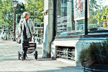 Woman walking with a rollator in a corona safe way on the streets of Amsterdam
