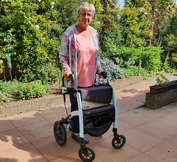 Woman using a walker that was transformed into a Parkinson rollator