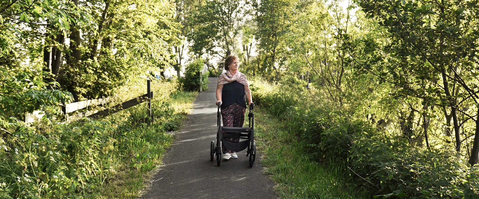 Vrouw loopt met een parkinson-rollator met verstelbare signalen