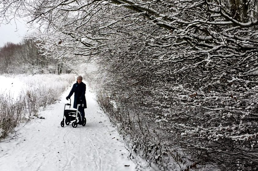 Woman walking with a Rollz Motion rollator walker in snow during winter